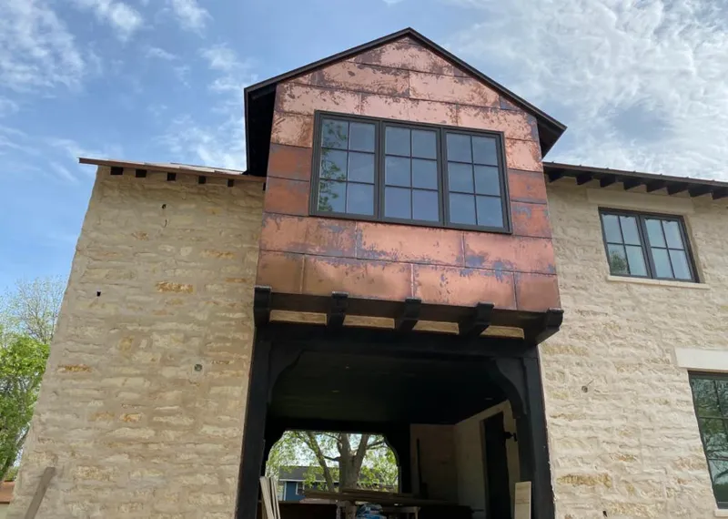 Copper metal panel facade on a stone building for Roof Repair in Meridian
