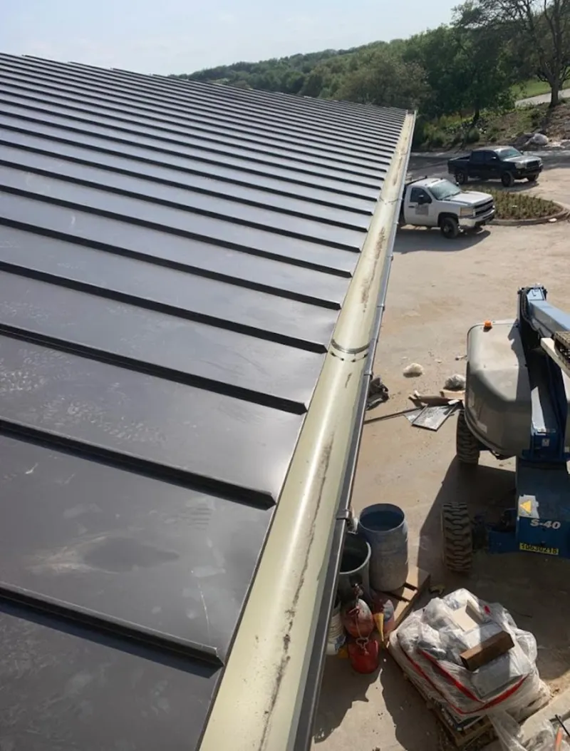 Standing seam panel and gutter detail on a metal roofing jobsite in Meridian